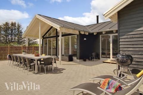 Den store terrasse er delvist overdækket og perfekt til at nyde en solrig sommerdag eller en hyggelig grillaften