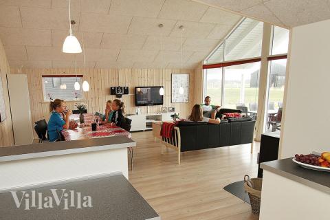 Opholdsrummet er dejlig lyst og rummeligt, og med komfortable møbler, brændeovn og fladskærms-tv husets helt naturlige samlingspunkt