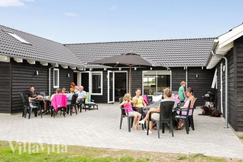 Udenfor kan man sole sig i gode havemøbler, eller grilles på den store terrasse. De mindste kan fortsætte legen i legetårnet og sandkassen