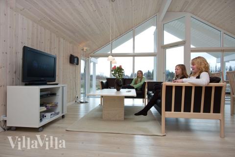 Opholdsrummet med sofagruppe og spisepladser er husets naturlige samlingspunkt