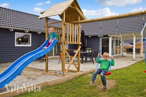Udendørs er der mulighed for at grille under den overdækkede terrasse - og børnene kan gynge, rutsche og lege i sandkassen/legetårnet.