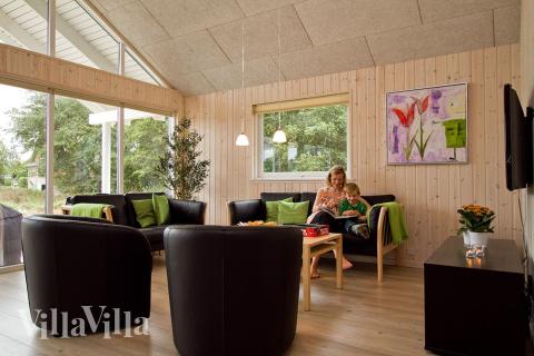 Sofagruppen er indrettet med komfortable møbler, brændeovn og fladskærms-tv