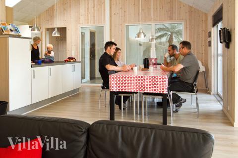 Opholdsrummet, som har kig til poolafdelingen, er smagfuldt indrettet med komfortable møbler, brændeovn og 65 \" fladskærms-TV