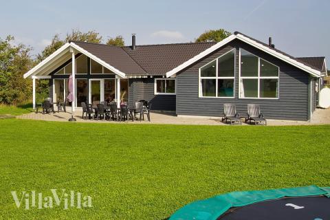 Udenfor er der også tænkt på de yngste - her er både trampolin og gyngestativ. Huset tilbyder en stor terrasse hvor der kan grilles og slappes af, hvis vejret tillader det