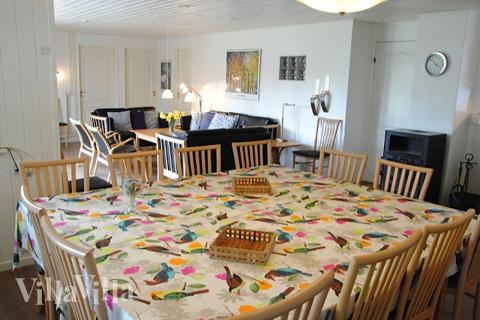 Opholdsrummet er husets helt naturlige samlingspunkt med køkken, spisepladser, brændeovn og sofagruppe med fladskærms-tv