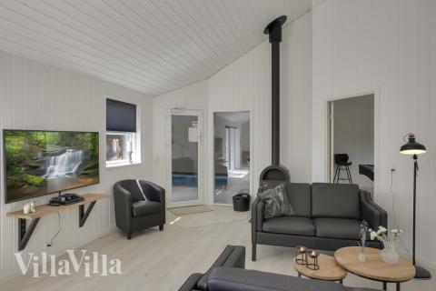 Husets omdrejningspunkt, køkken-alrummet, hænger sammen med stuen som er hyggeligt indrettet med brændeovn og smagfulde møbler