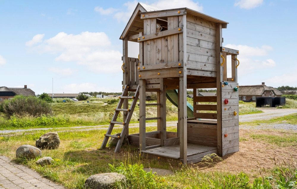 I det attraktive aktivitesrum i luksushus nr. 294 i Vestjylland  er der masser af udendørs aktiviteter, f.eks. legetårn og gynge