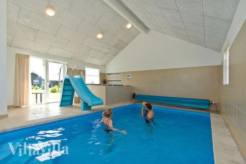 Både store og små vandhunde kan boltre sig i timevis i husets pool med romersk trappe, modstrømsanlæg og vandrutsjebane