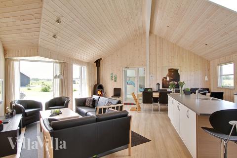Opholdsrummet er rummeligt og husets naturlige samlingspunkt med sofagruppe og spisepladser