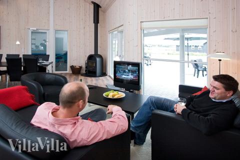 De komfortable møbler, fladskærms-tv\'et og brændeovnen i opholdsrummet indbyder til hygge og afslapning