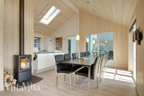 Opholdsrummet er dejlig lyst og rummeligt, og med komfortable møbler, brændeovn og fladskærms-tv husets helt naturlige samlingspunkt