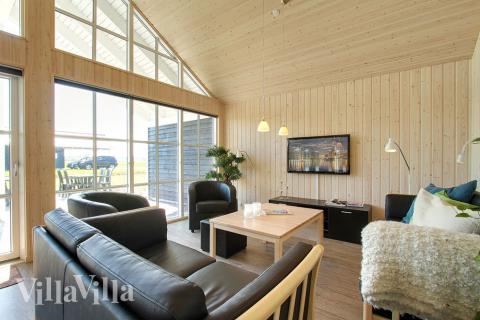 Stuen er hyggeligt indrettet med sofaer og brændeovn, som kan give lidt ekstra hygge og varme på en kølig dag