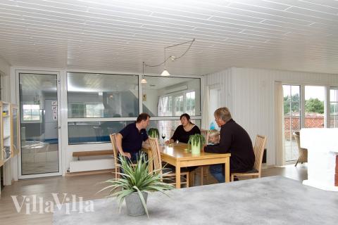 Det store opholdsrum er indrettet med køkken, spisepladser og sofagruppe med fladskærms-tv