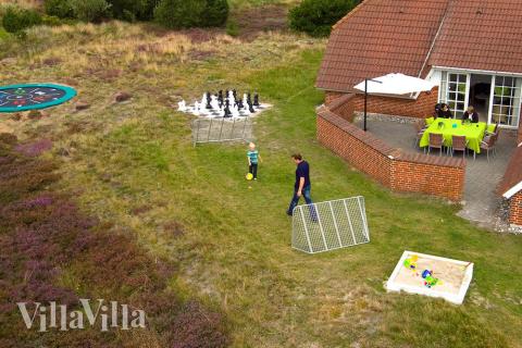 Den store terrasse er perfekt til at solbade og grille. Til børnene er der både tramponlin, skakspil, sandkasse og gynger