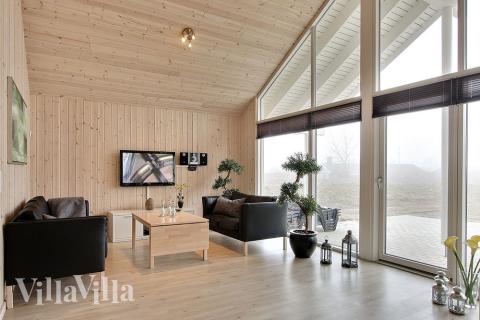 De komfortable møbler, fladskærms-tv\'et og brændeovnen i opholdsrummet indbyder til hygge og afslapning