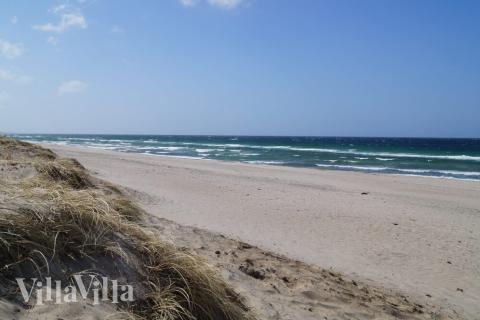 Stranden nær luksushus nr. 275 i Nordsjælland indbyder til en gåtur.