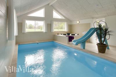 Sommerhuset har en luksuriøs poolafdeling med stor pool, vandrutsjebane og et stort spabad samt sauna