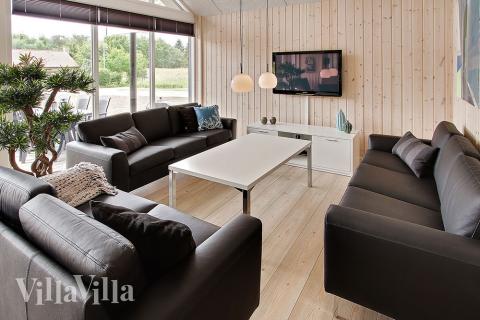 Stuen er hyggelgt indrettet med sofaer og brændeovn, som kan give lidt ekstra hygge og varme på en kølig dag