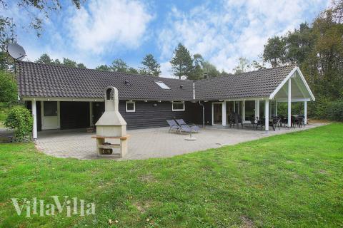 På den store og delvist overdækkede terrasse kan solen nydes på en solrig dag eller grilles en lækker middag til familie og venner