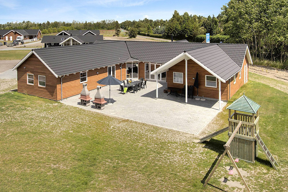 Stort poolhus i Marielyst fyldt med skønne detaljer f.eks. legehus med tårn, legehule, glidebane i træ, klatrevæg og dobbelt gyngestativ