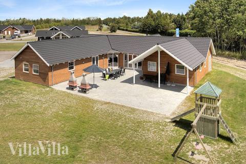 Stort poolhus i Marielyst fyldt med skønne detaljer f.eks. legehus med tårn, legehule, glidebane i træ, klatrevæg og dobbelt gyngestativ