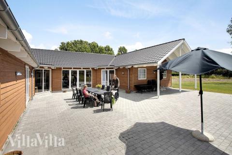 Husets skønne terrasse, som er delvist overdækket, er med havemøbler og 2 stensgrill de perfekte rammer på en solrig sommerdag