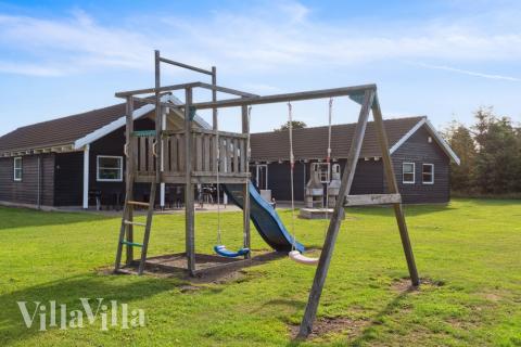 I det attraktive aktivitesrum i luksushus nr. 208 i Lolland/Falster/Møn  er der masser af udendørs aktiviteter, f.eks. legetårn og gynge