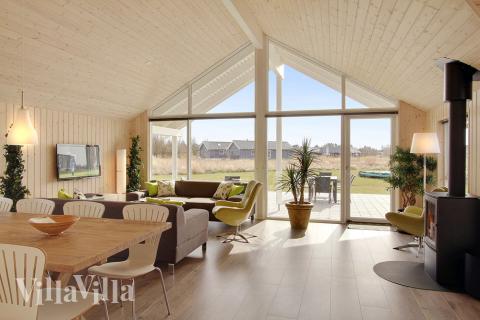 Opholdsrummet er dejlig lyst og rummeligt, og med komfortable møbler, brændeovn og fladskærms-tv husets helt naturlige samlingspunkt