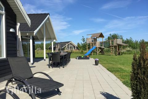 Den delvist overdækkede terrasse er perfekt til en sommerdag eller en grillaften, og til de mindste gæster er der sandkasse og gynge