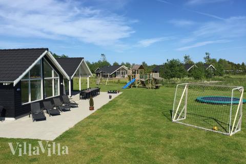 I det attraktive aktivitesrum i luksushus nr. 305 i Lolland/Falster/Møn  er der masser af udendørs aktiviteter, f.eks. legetårn og gynge