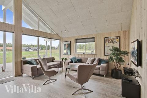 Sofagruppen er indrettet med komfortable møbler, brændeovn og fladskærms-tv