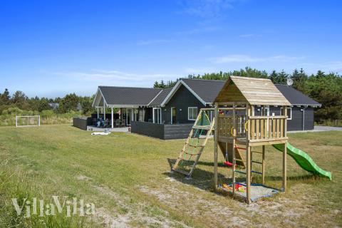 I det attraktive aktivitesrum i luksushus nr. 311 i Vestjylland  er der masser af udendørs aktiviteter, f.eks. legetårn og gynge