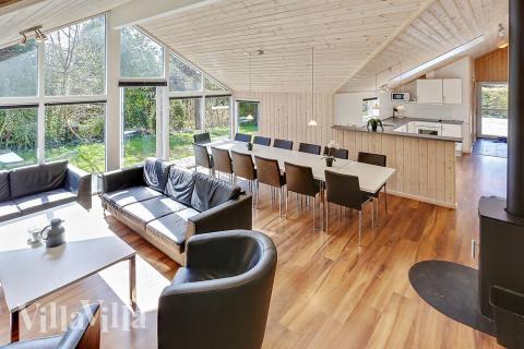 Opholdsrummet med det store vinduesparti er husets naturlige samlingspunkt med spisepladser og sofagruppe med fladskærms-tv