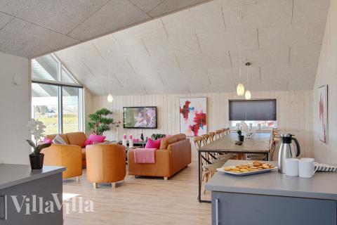 Opholdsrummet med det store vinduesparti er husets naturlige samlingspunkt med spisepladser og sofagruppe med fladskærms-tv