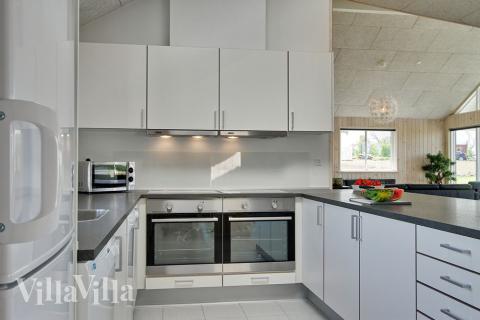 Luksuriøst og funktionelt køkken med to ovne, to opvaskemaskiner og god plads.