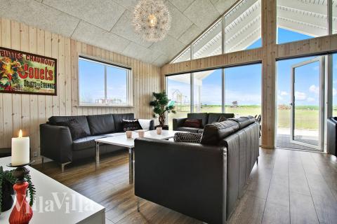 Hyggeligt, indrettet stue tæt på brændeovnen – rigtig sommerhusstemning.