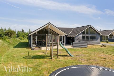 I det attraktive aktivitesrum i luksushus nr. 396 i Vestjylland  er der masser af udendørs aktiviteter, f.eks. legetårn og gynge