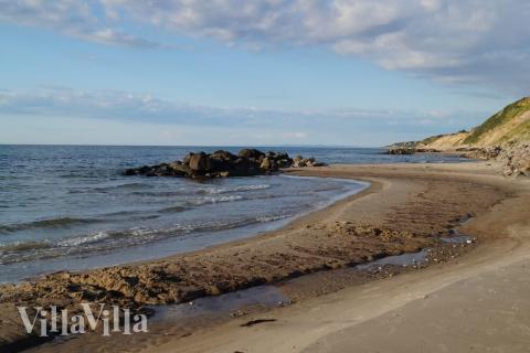Stranden nær luksushus nr. 388 i Nordsjælland indbyder til en gåtur.