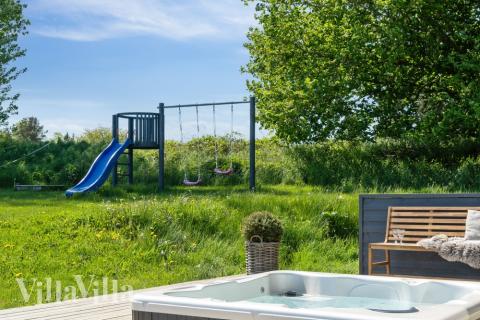 I det attraktive aktivitesrum i luksushus nr. 397 i Nordsjælland  er der masser af udendørs aktiviteter, f.eks. legetårn og gynge