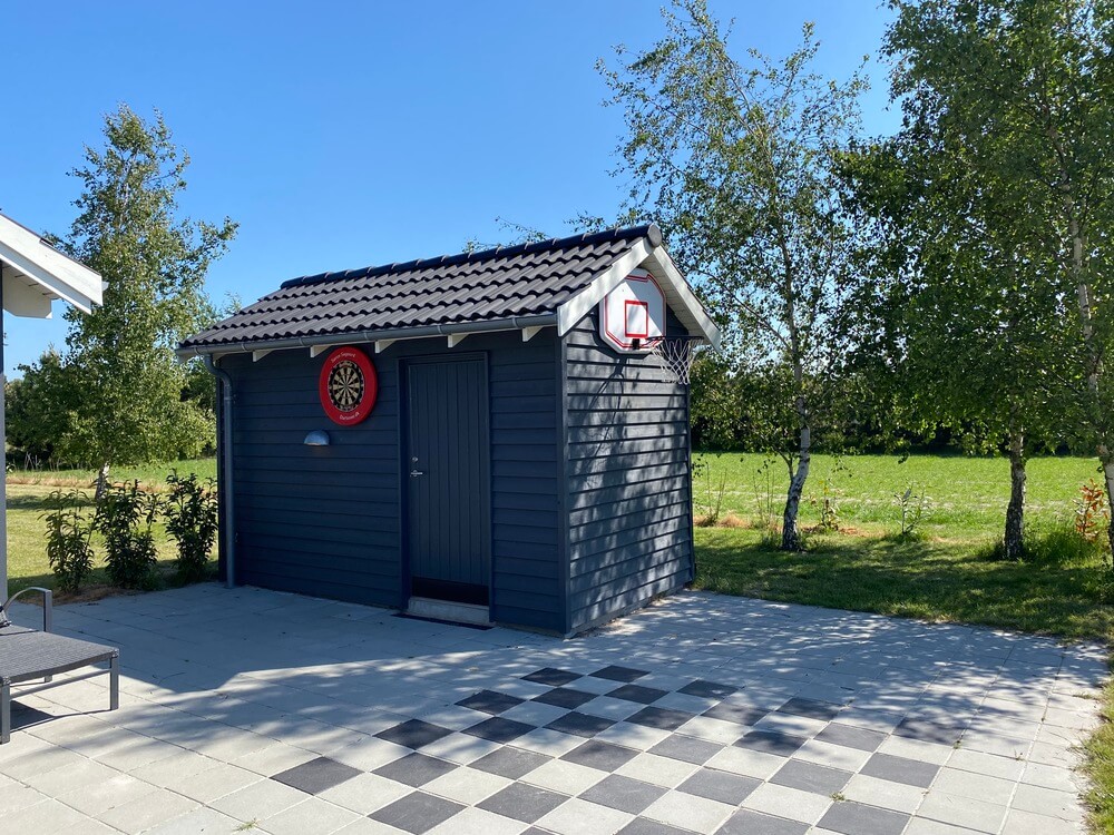 I det attraktive aktivitesrum i luksushus nr. 413 i Lolland/Falster/Møn  er der masser af udendørs aktiviteter, f.eks. legetårn og gynge