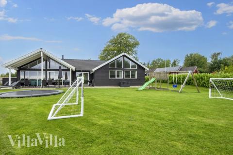 I det attraktive aktivitesrum i luksushus nr. 421 i Østjylland  er der masser af udendørs aktiviteter, f.eks. legetårn og gynge