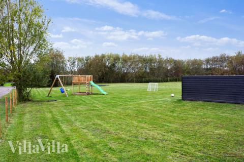 I det attraktive aktivitesrum i luksushus nr. 433 i Lolland/Falster/Møn  er der masser af udendørs aktiviteter, f.eks. legetårn og gynge