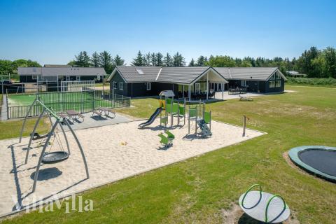 I det attraktive aktivitesrum i luksushus nr. 454 i Vestjylland  er der masser af udendørs aktiviteter, f.eks. legetårn og gynge