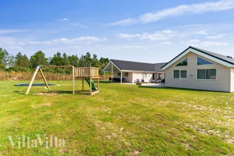 I det attraktive aktivitesrum i luksushus nr. 463 i Vestjylland  er der masser af udendørs aktiviteter, f.eks. legetårn og gynge