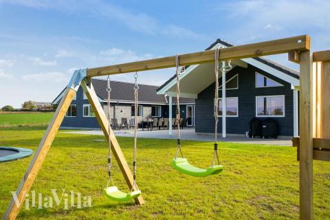 I det attraktive aktivitesrum i luksushus nr. 447 i Lolland/Falster/Møn  er der masser af udendørs aktiviteter, f.eks. legetårn og gynge