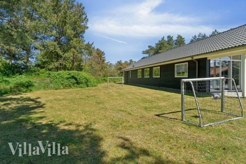 I det attraktive aktivitesrum i luksushus nr. 449 i Bornholm  er der masser af udendørs aktiviteter, f.eks. legetårn og gynge