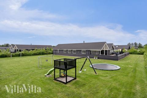 I det attraktive aktivitesrum i luksushus nr. 460 i Vestjylland  er der masser af udendørs aktiviteter, f.eks. legetårn og gynge