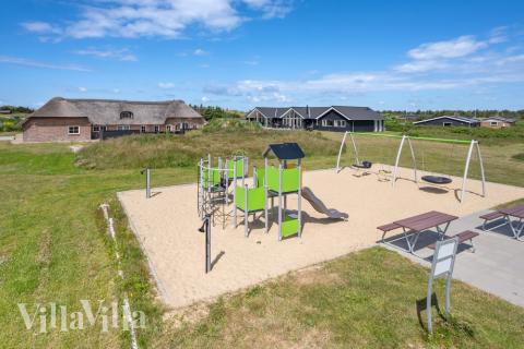 I det attraktive aktivitesrum i luksushus nr. 528 i Vestjylland  er der masser af udendørs aktiviteter, f.eks. legetårn og gynge