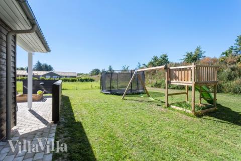 I det attraktive aktivitesrum i luksushus nr. 523 i Nordjylland  er der masser af udendørs aktiviteter, f.eks. legetårn og gynge