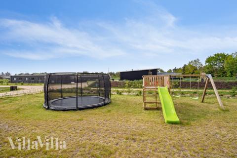 I det attraktive aktivitesrum i luksushus nr. 535 i Vestjylland  er der masser af udendørs aktiviteter, f.eks. legetårn og gynge